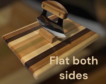 Peut inclure: Une planche à découper en bois avec un motif rayé multicolore. Un couteau incurvé avec un manche en bois repose sur la planche. Le texte "Flat both sides" est imprimé sur la planche.