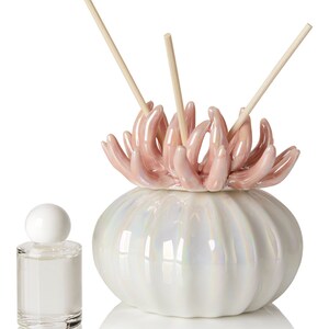 May include: White ceramic diffuser shaped like a seashell with a pink coral top and wooden diffuser sticks.