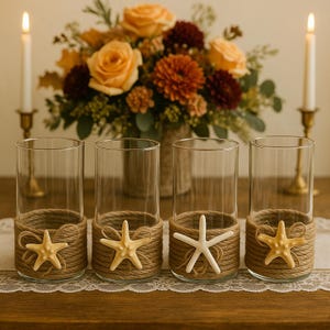 May include: Four clear glass cylinder vases wrapped at the base with thick tan jute rope. Each vase features a decorative starfish attached to the front of the rope wrapping. The starfish vary in color from light yellow to off-white.