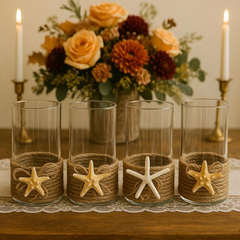 May include: Four clear glass cylinder vases wrapped at the base with thick tan jute rope. Each vase features a decorative starfish attached to the front of the rope wrapping. The starfish vary in color from light yellow to off-white.