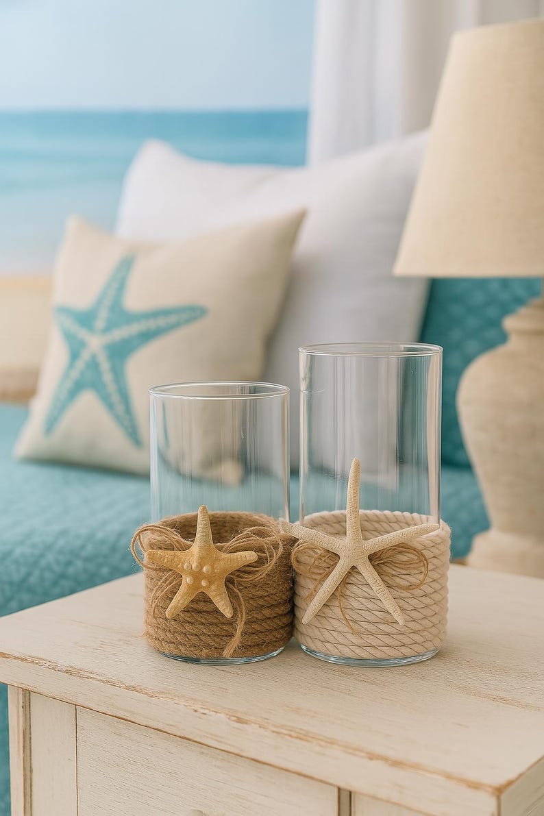 May include: Two clear glass cylindrical candle holders. One is wrapped in brown jute twine with a tan starfish and a small twine bow. The other is wrapped in cream-colored rope with a white starfish and a matching cream-colored rope bow.