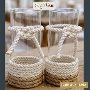 May include: Two clear glass vases with a rope design. The vases have a natural rope base and a white rope detail around the middle. The text "Single Vase" is at the top, and "Bulk Available" is at the bottom.
