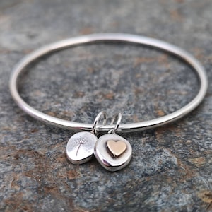 A gorgeous silver bangle with two pebble charms.