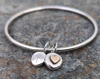 A gorgeous silver bangle with two pebble charms.