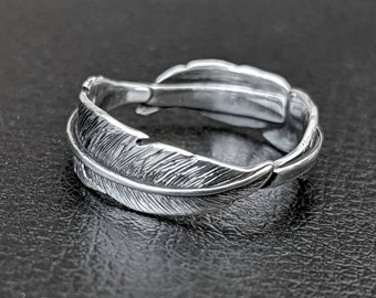 A thin continuous silver feather ring