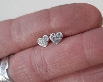 Small textured silver heart stud earrings.