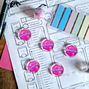 May include: A character sheet for a tabletop role-playing game, with a pink dice that says "Inspiration" on it. The sheet has a character name, "Elsie "Elly" Mushfriend", and stats for strength, constitution, intelligence, wisdom, charisma, and saving throws. There are also several other dice on the sheet, including a blue and white dice.