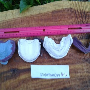 May include: Four small, heart-shaped, painted wooden crafts. One is purple and blue, two are white, and one is purple. A pink ruler is above them. The text "FurEverFlowersCrafts" and "#11" is on a white label.