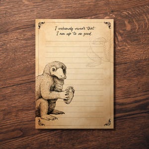 May include: A lined notepad with a vintage aesthetic, featuring a sepia-toned illustration of a Niffler holding a coin. The text "I solemnly swear that I am up to no good" is printed at the top, with decorative flourishes.