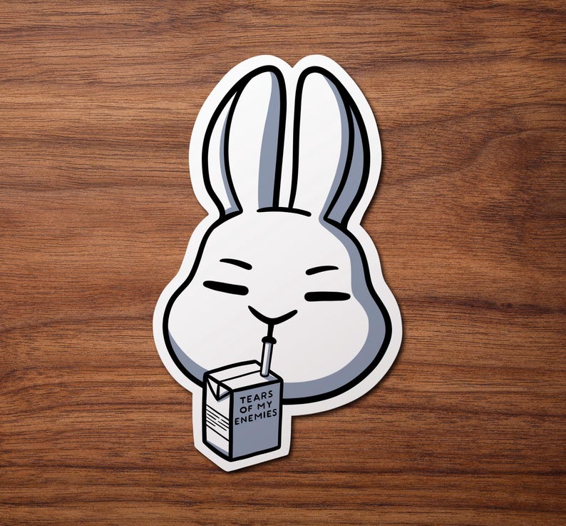 May include: A white rabbit cartoon character with a straw in its mouth drinking from a carton of juice that says "Tears of My Enemies".