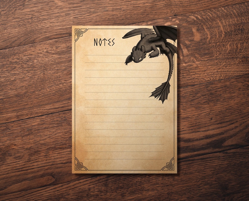 May include: A lined notepad with the word "NOTES" at the top and a black dragon illustration in the upper right corner. The notepad has a decorative border and is set on a wooden surface.
