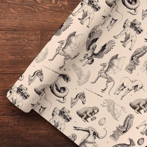 Könnte beinhalten: Eine Rolle cremefarbenes Papier mit einem sich wiederholenden Muster aus schwarzen Tuschezeichnungen verschiedener Fabelwesen, darunter dreiköpfige Hunde, geflügelte Drachen, auf Büchern sitzende Eulen und kleine Eier in einem dichten Raster.
