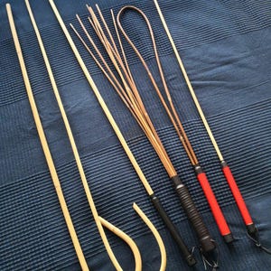 Puede incluir: Un conjunto de seis látigos de madera, que incluyen un látigo tradicional, una fusta y un bastón. Los látigos están hechos de madera natural y tienen una variedad de colores y texturas.