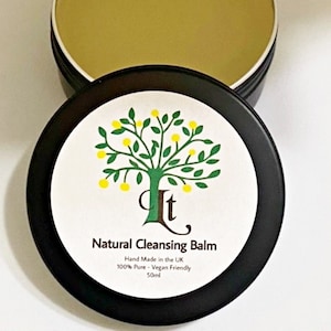 May include: A black jar with a white label that reads "Natural Cleansing Balm", "Hand Made in the UK", "100% Pure - Vegan Friendly", and "50ml". The jar is open and the balm inside is a light yellow color.