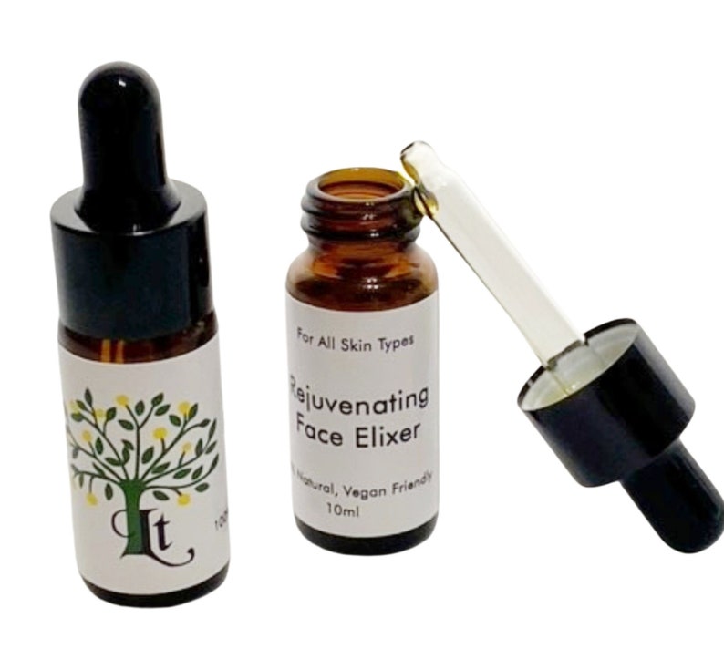 May include: Two amber glass bottles with black dropper tops and white labels. The label on the bottle on the right reads "For All Skin Types Rejuvenating Face Elixir Natural, Vegan Friendly 10ml".