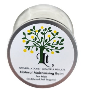 May include: A silver tin with a white label featuring a green tree with yellow fruit. The label reads "Naturally Done - Beautiful Results Natural Moisturising Balm For Men Sandalwood And Bergamot".