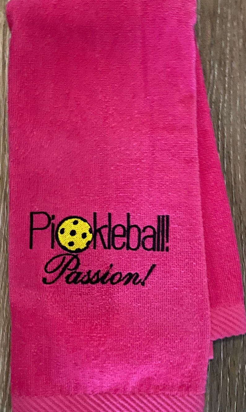 May include: Pink towel with black embroidery that reads "Pickleball! Passion!" and a yellow pickleball graphic.