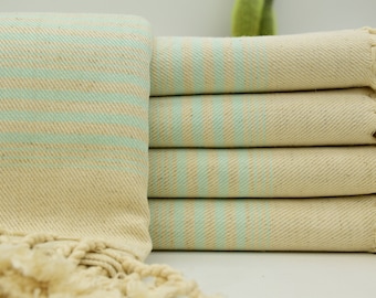 May include: A stack of light beige towels with thin, light blue stripes. The towels have fringe on the ends.