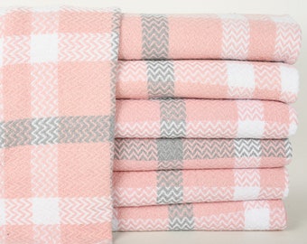 May include: A stack of pink and gray checkered towels. The towels are folded and stacked on top of each other.