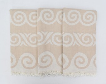 May include: Three beige towels with a white swirl pattern. The towels have a fringe border.
