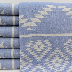 Peut inclure: Un lot de six serviettes turques &agrave; motifs bleus et blancs. Les serviettes pr&eacute;sentent un motif g&eacute;om&eacute;trique avec des triangles et des losanges blancs sur un fond bleu clair.