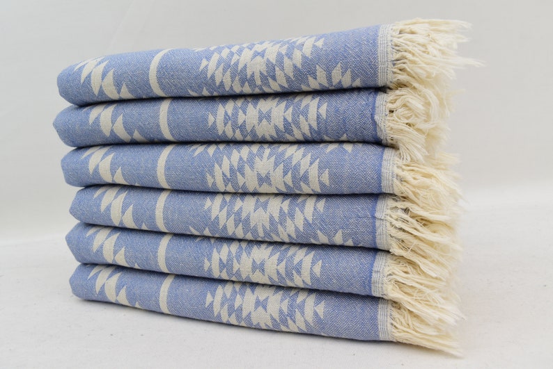 Peut inclure: Une pile de six serviettes turques &agrave; motifs bleus et blancs avec des bords frang&eacute;s.