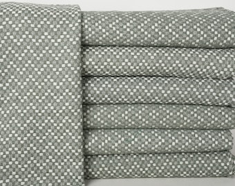 May include: A stack of seven green and white checkered towels. The towels are folded and stacked neatly.