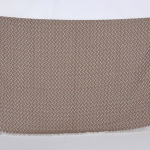May include: A brown and white patterned throw blanket with a fringed edge.