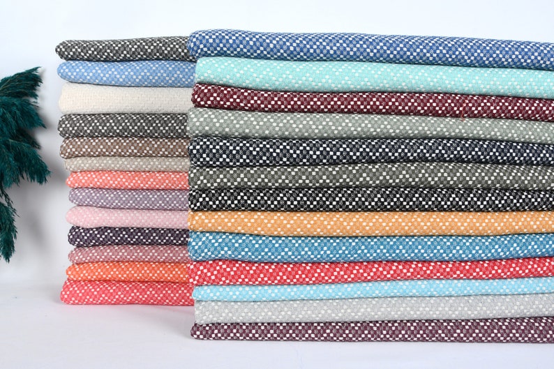 May include: A stack of 20 different patterned fabrics in various colors, including blue, green, red, orange, and brown. The fabrics have a small, white, geometric pattern.