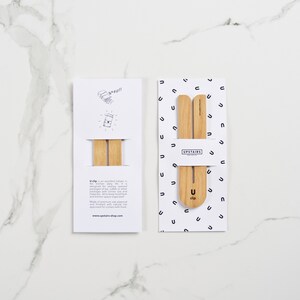 May include: Two packages of wooden U-clips, a product designed to help keep bags of coffee beans fresh. The packaging is white with black text and a simple illustration of the product. The text on the packaging reads "Upstairs" and "U-clip".