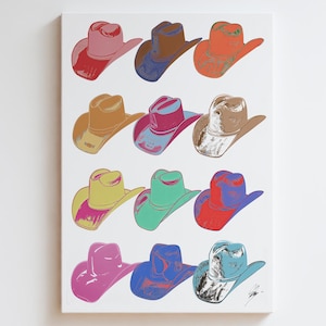 May include: A pop art style canvas print featuring a grid of twelve cowboy hats in various colors. The hats are depicted in shades of pink, brown, orange, yellow, green, and blue, with white highlights. The artwork is mounted on a white canvas.