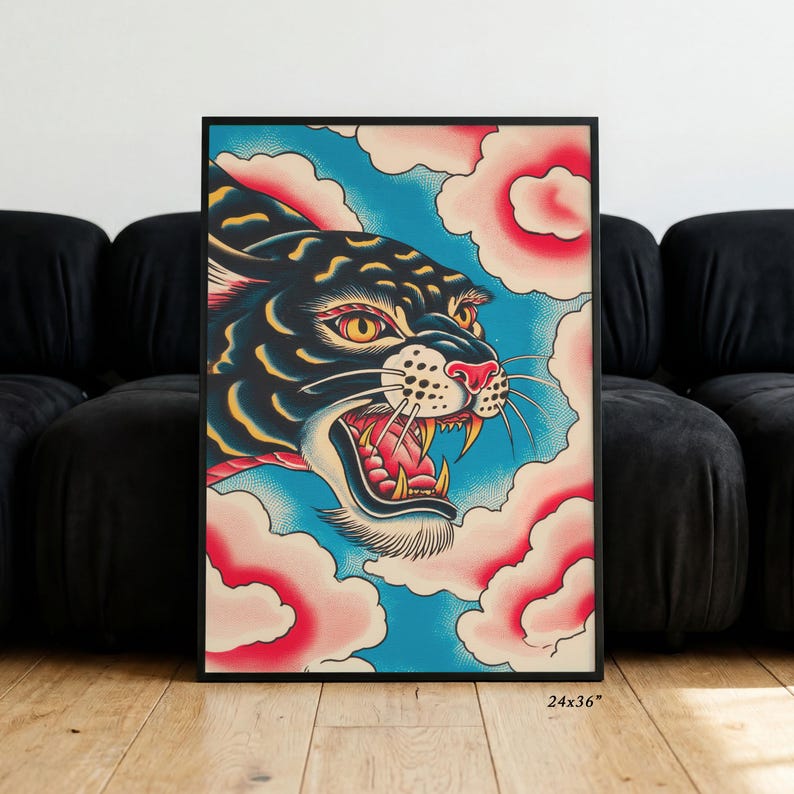 May include: A framed wall art print featuring a black panther with yellow eyes and an open mouth showing teeth, set against a bright blue background with stylized pink and white clouds. The print measures 24 inches by 36 inches in size.