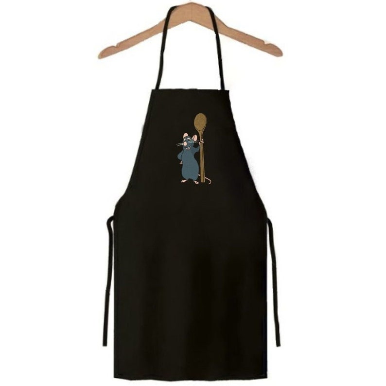 Puede incluir: Delantal de cocina negro con una rata de dibujos animados sosteniendo una cuchara de madera. La rata lleva un gorro de cocinero.