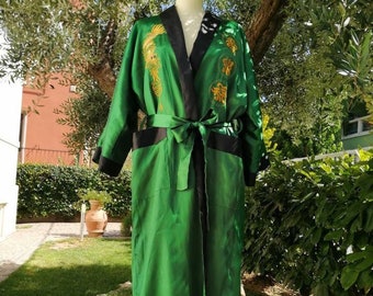 May include: A green silk robe with gold embroidery of a dragon and other Chinese symbols. The robe has a black trim and a black sash.