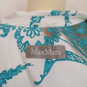 May include: A white blouse with a turquoise floral pattern and a MaxMara label.