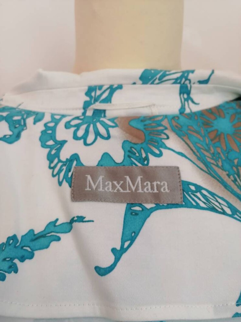 May include: A white blouse with a turquoise floral pattern and a MaxMara label.