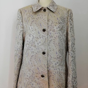 May include: A long-sleeved, button-up jacket with a paisley pattern in shades of gold, silver, and purple.