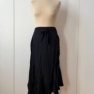 May include: A black midi skirt with a drawstring waist and a ruffled hem.