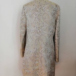 May include: A long-sleeved jacket with a paisley pattern in shades of gold, purple, and white.