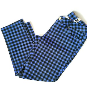 Può includere: Pantaloni a quadri blu e neri con un piccolo cartellino bianco con la scritta "M" in vita.