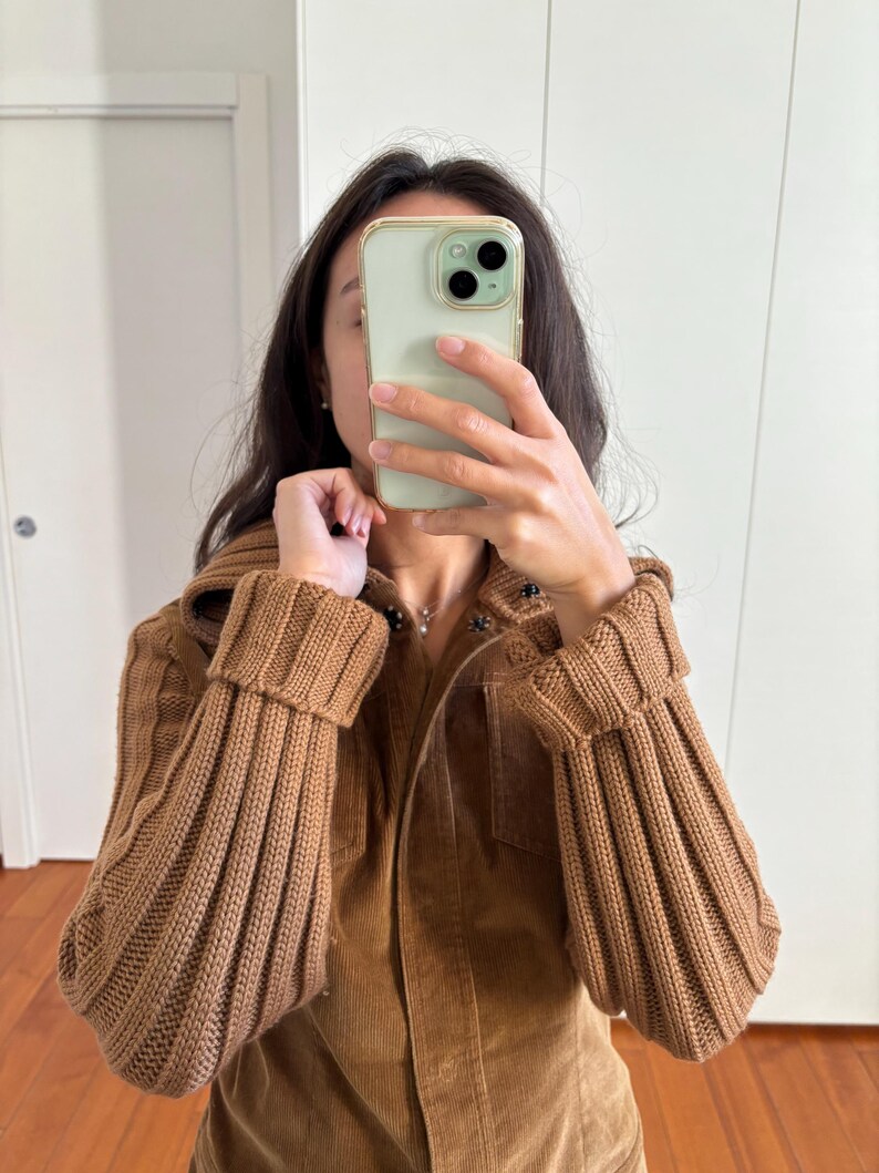 May include: A brown corduroy jacket with a zipper closure and ribbed knit sleeves. The jacket has a stand-up collar and two pockets on the front.
