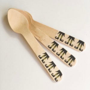 Puede incluir: Conjunto de cuatro cucharas de madera con un diseño de bota de bruja. Las cucharas son marrones y tienen un patrón de bota de bruja negro y amarillo.