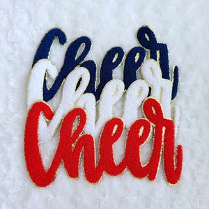 May include: Three layered felt patches spelling out "Cheer" in red, white, and navy blue with gold outlining.