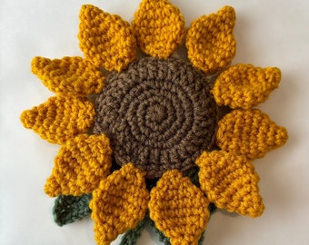 Haakpatroon: woondecoratie zonnebloem op tafel. Het patroon kan worden aangepast om te worden gebruikt als warme seizoensmat of onderzetter. Gemiddeld vaardigheidsniveau.