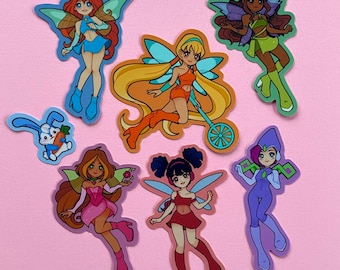 May include: A set of ten colorful cartoon character stickers featuring fairies, a bunny, and a magical creature. The stickers are printed on a glossy, white background.