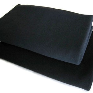 May include: Two black fleece blankets stacked on top of each other.