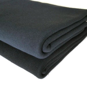 May include: Two folded pieces of black fabric. The fabric is soft and has a smooth texture.