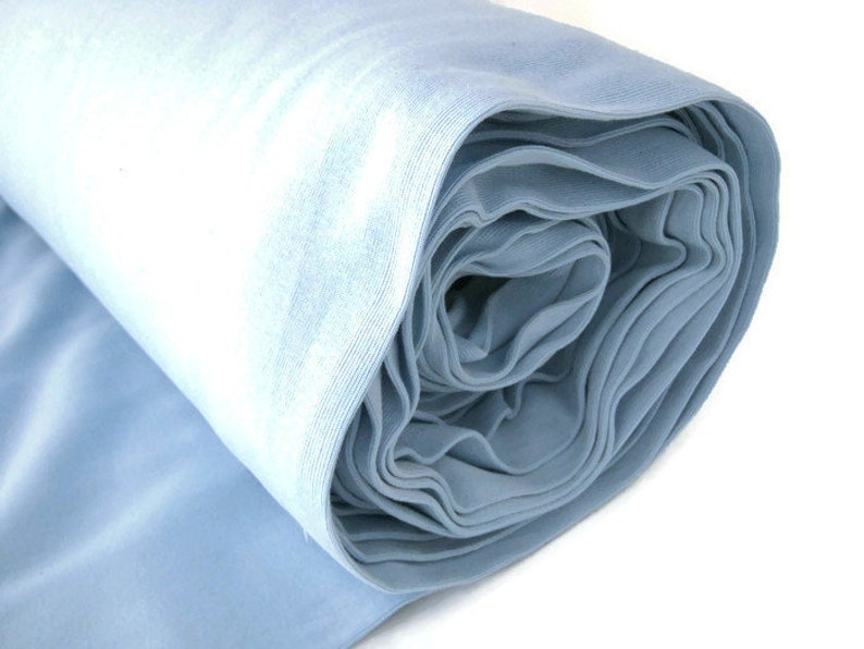 May include: A roll of light blue fabric. The fabric is soft and smooth, and it is perfect for sewing projects.