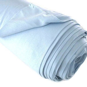 May include: A roll of light blue fabric, folded and rolled up. The fabric is smooth and soft.
