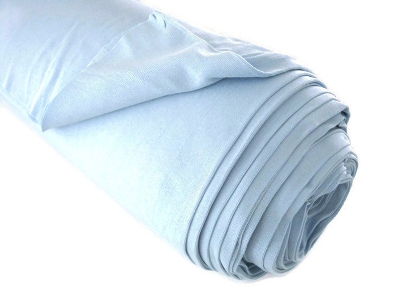 May include: A roll of light blue fabric, folded and rolled up. The fabric is smooth and soft.